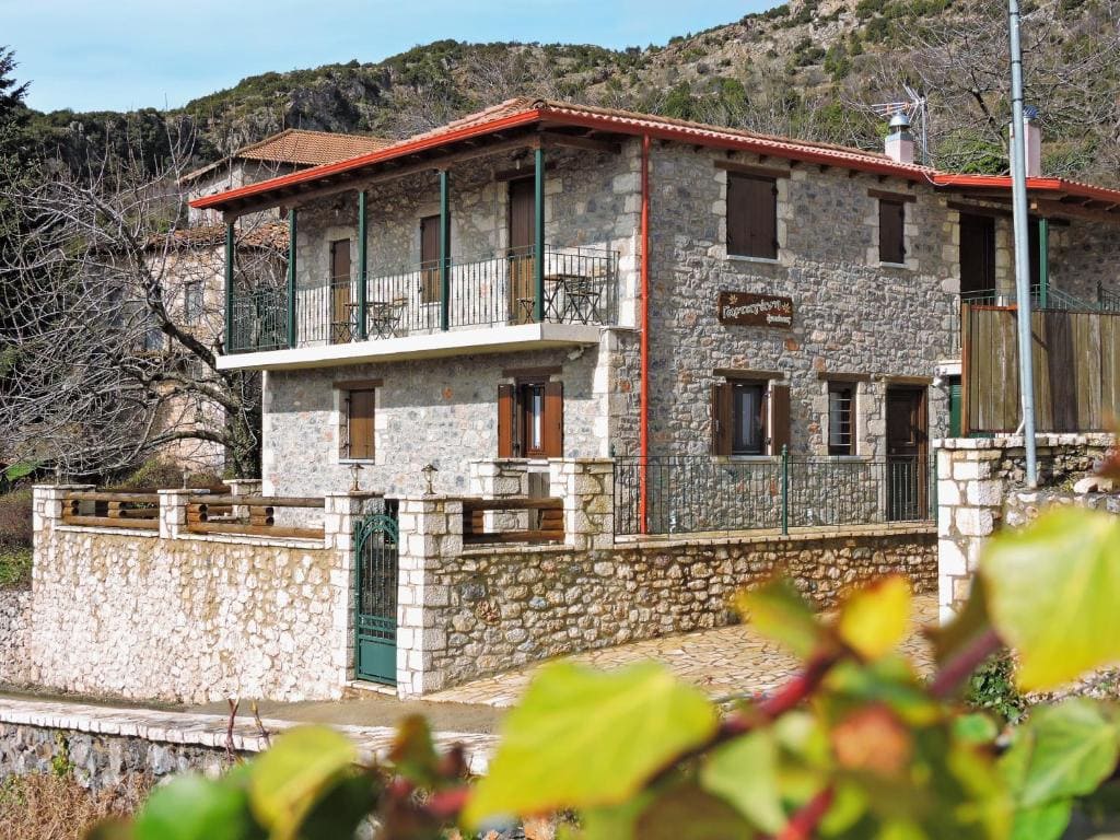 Gartagani Guest house - stone building with mountains behind it 