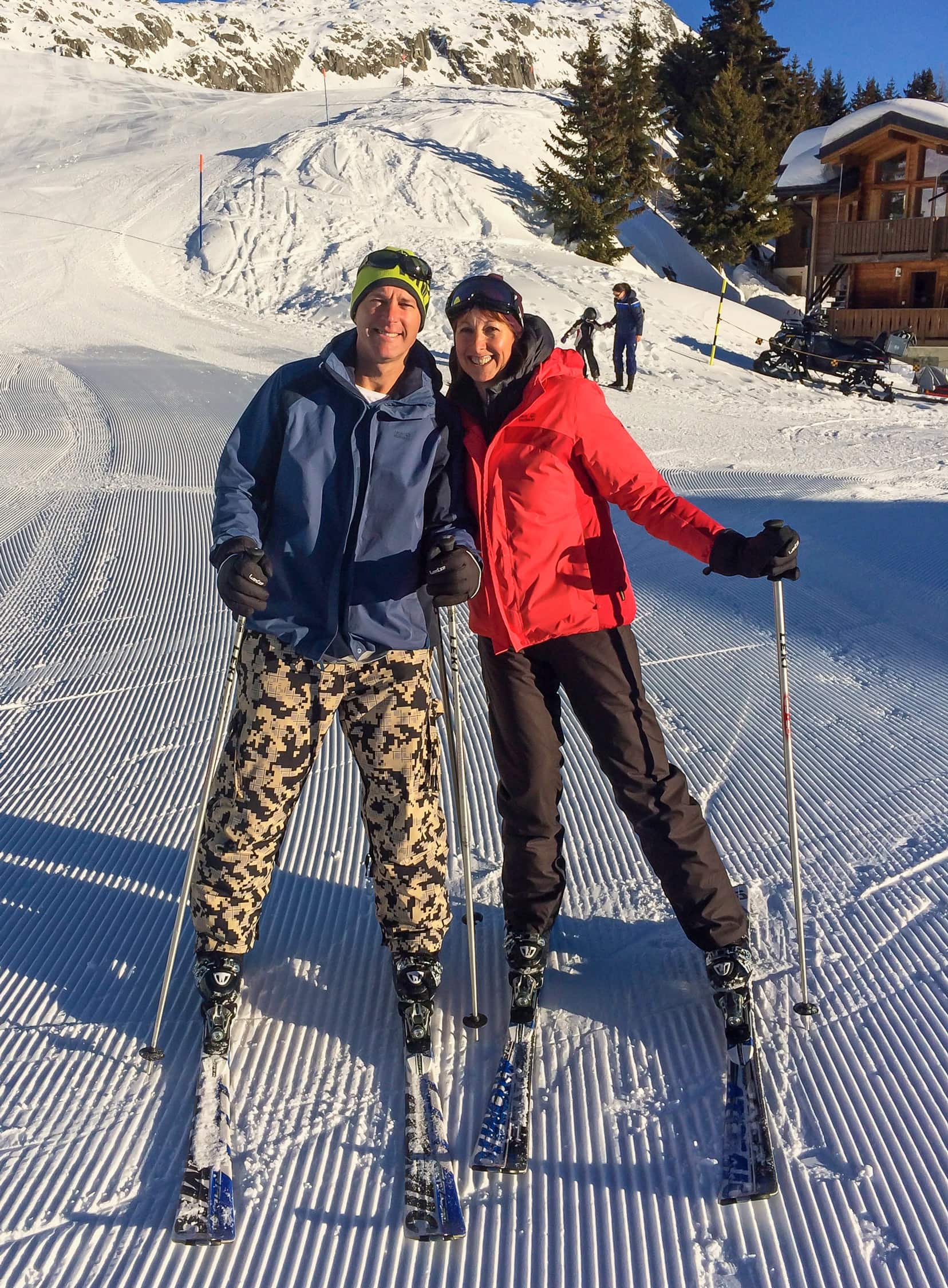 2-people-on-skis-with-a-snowy-mountain-backdrop