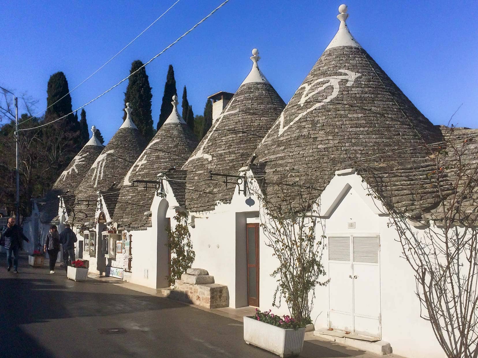 Alberobello Trulli with painted white symbols on the cone shaped stone roofs and whitewashed walls