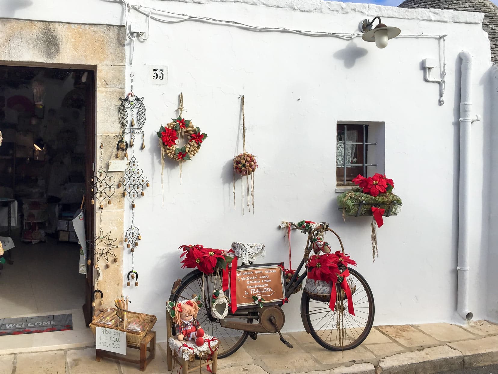 Red bycycle outside an alberobello house