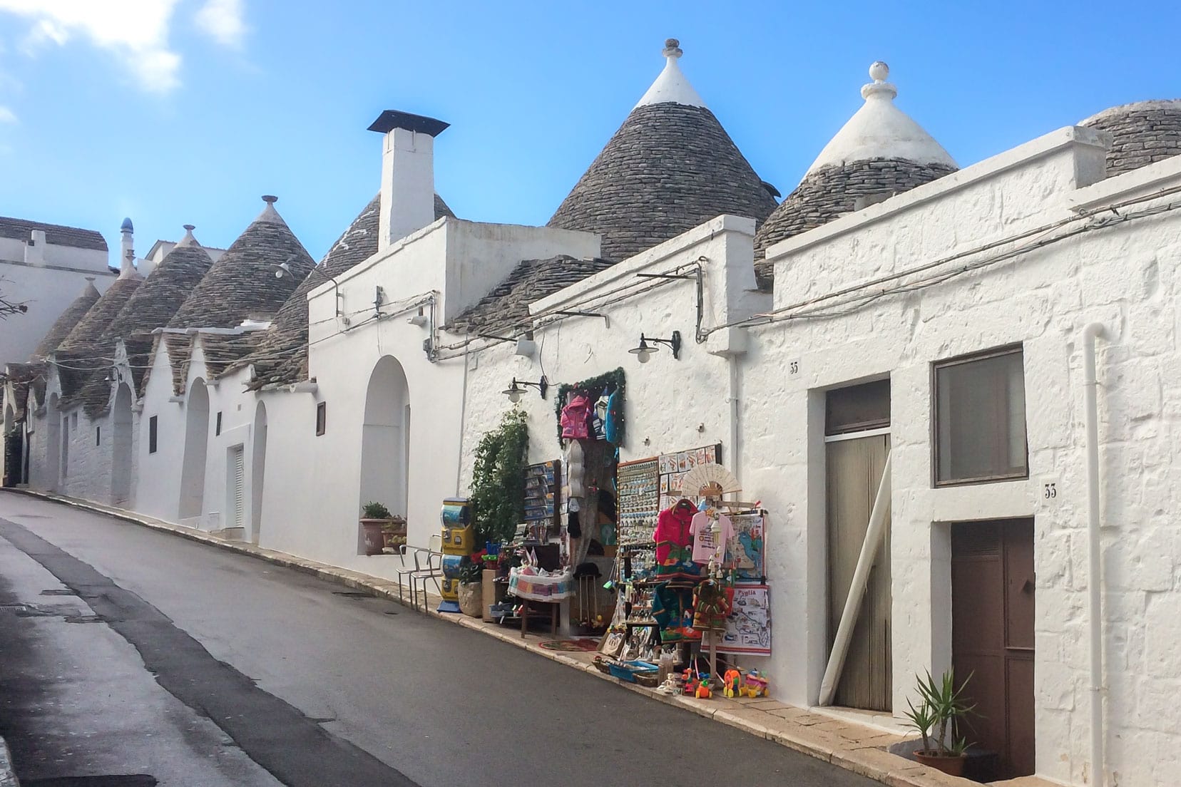 Trulli in the rione monti area with one decorated outside wth lots of wares fro sale icluding teshirts, magnets, toys