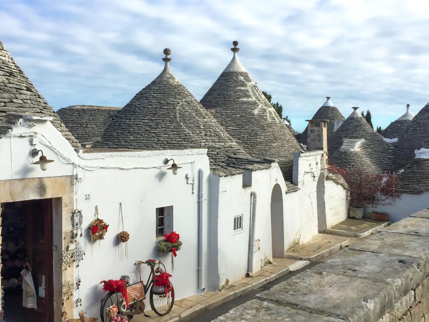 Alberobelli trulli in a row with different pinnacles- round and flat