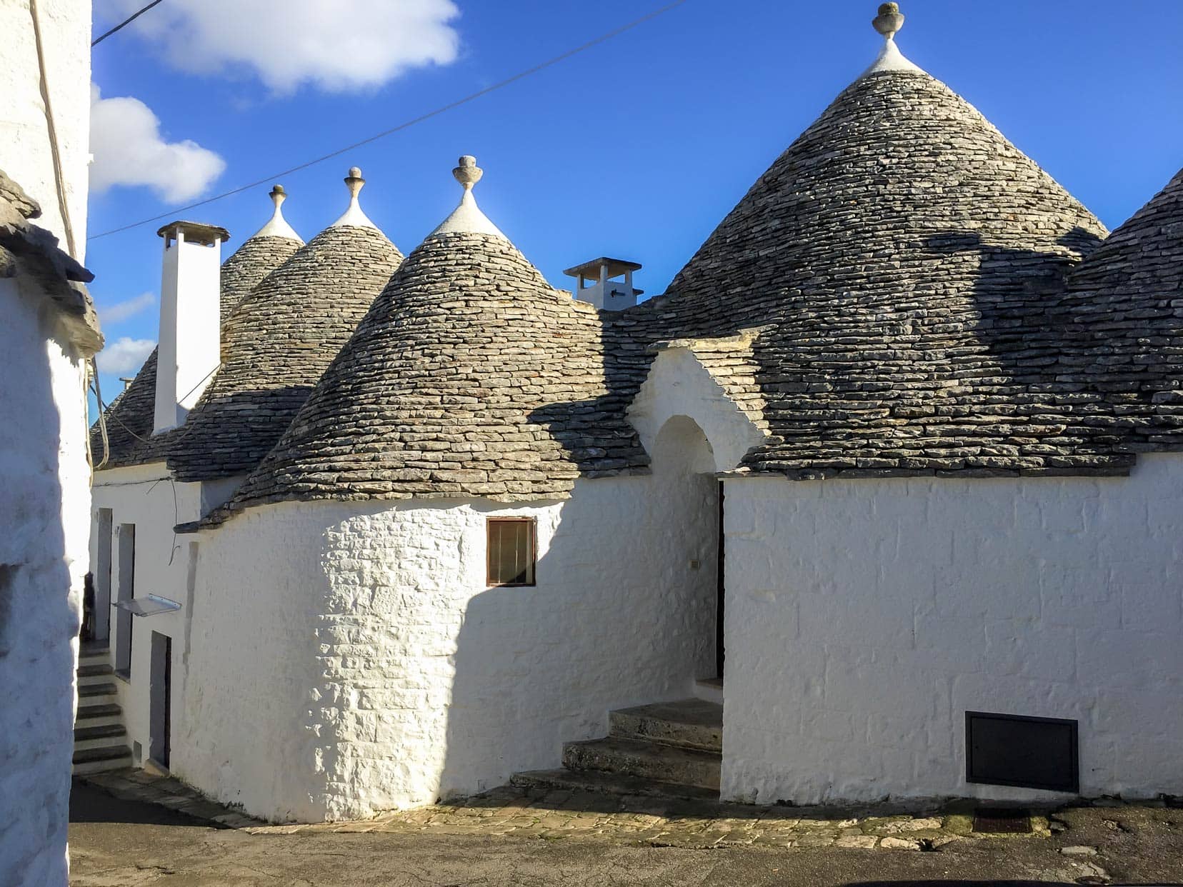 Trulli buildings with grey stone coned roofs and white washed walls 