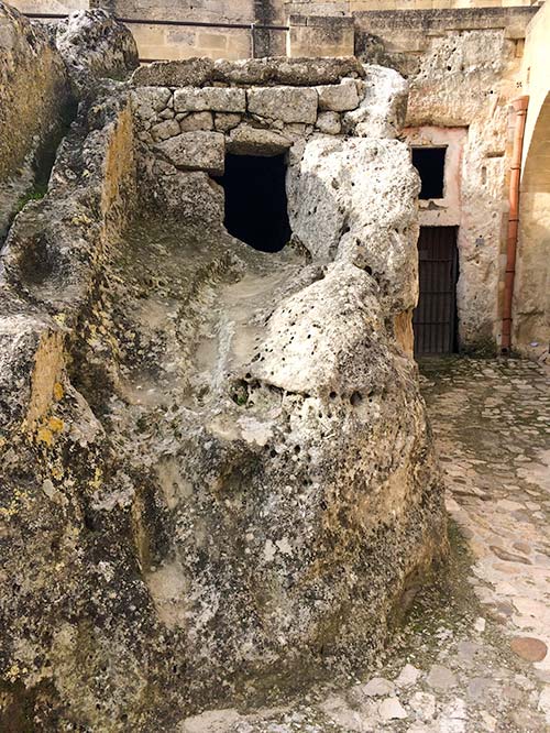 hole in a rock that used to be a home in the Sassi di Matera Italy