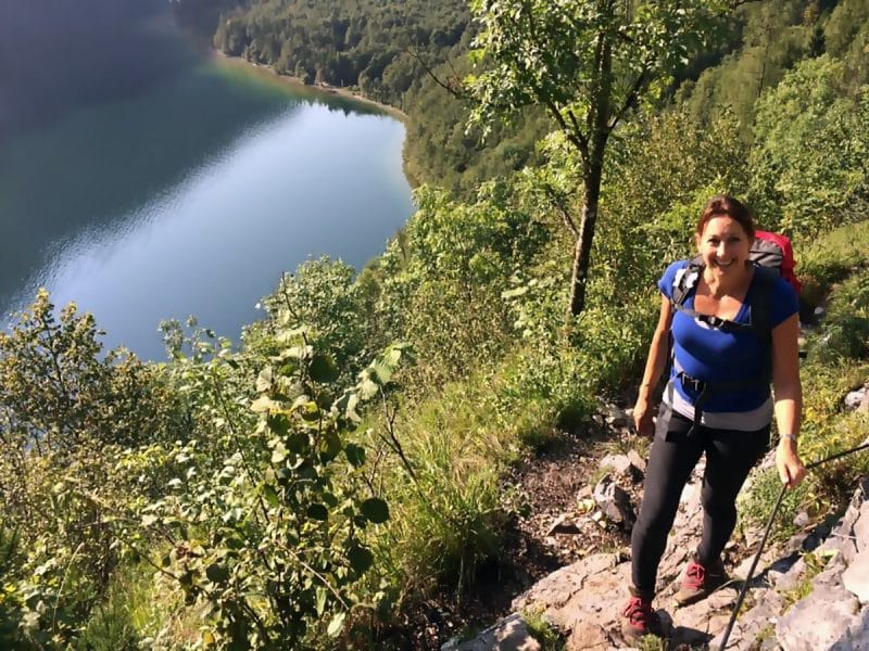 Michelle on a walking path high up above a lake with lots of green trees around