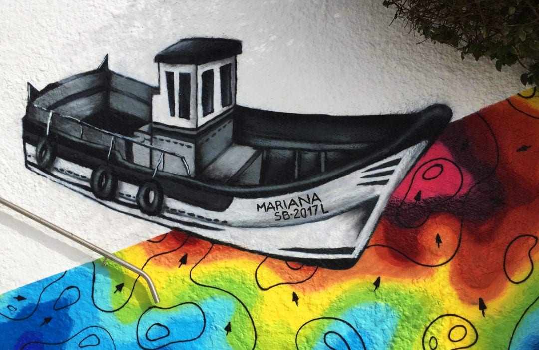 Sesimbra street art with mural of black and white boat on coloured swirls
