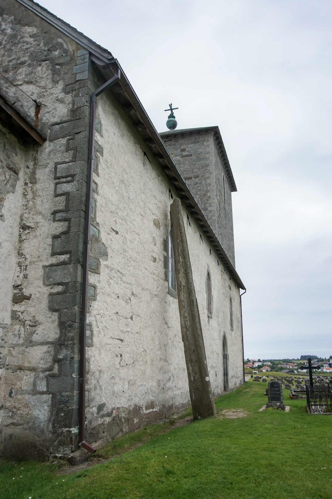Avaldnes_St-Olav’s-Avaldsnes-Church,-with-the-legendary-Stone-‘Needle’-