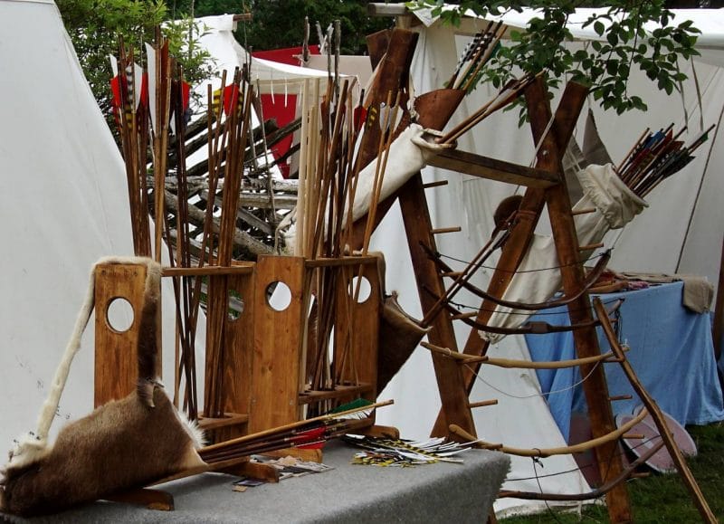 Many wooden arrows and wooden bows on display at the viking festival