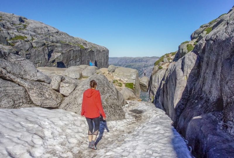 Lady walking down an ice covered path towards Kjeragbolten