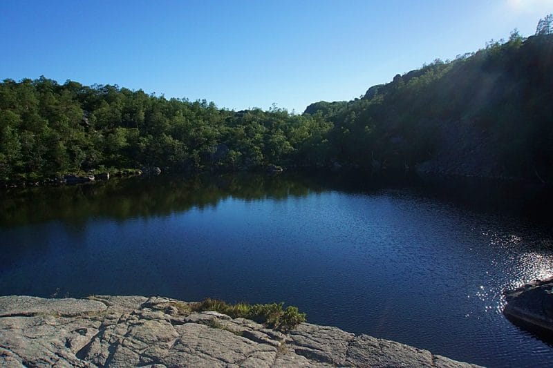 Lake surrounded by rocks and green trees