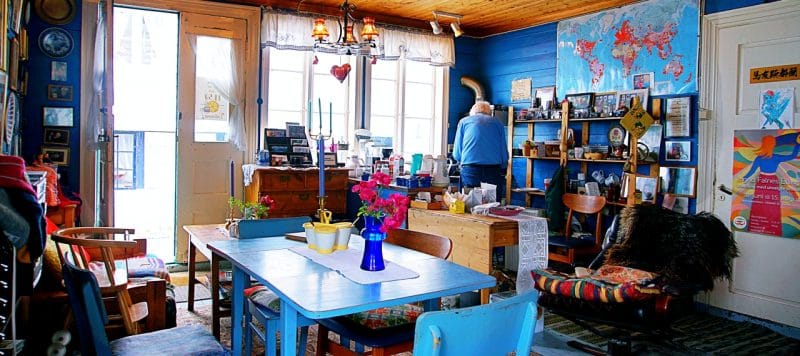 The inside of the cafe majorstuen, a blue table and chairs is in the foreground. The entrance and window are in the background. A world map is on the wall.