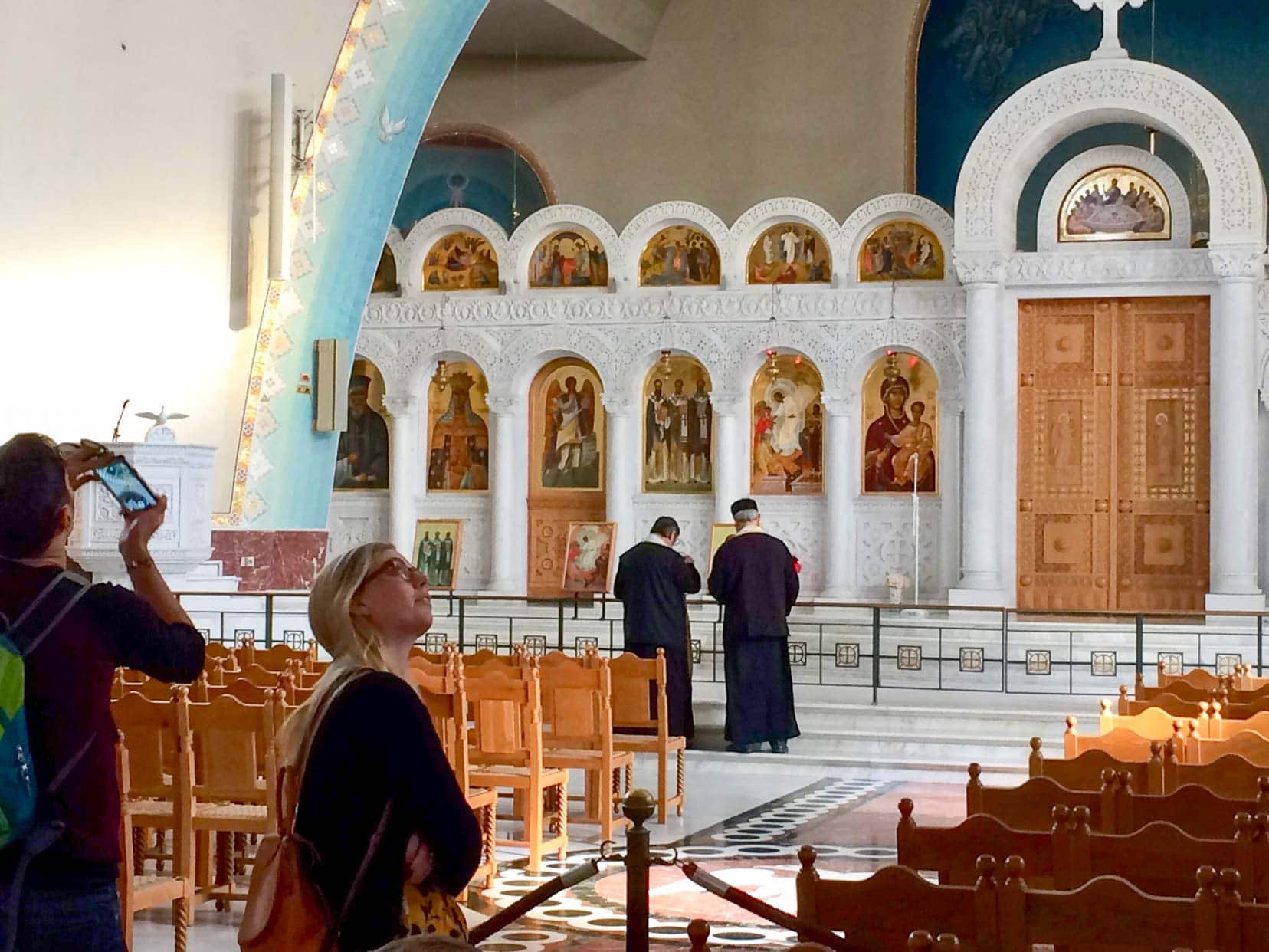 Campervanning-in-Albania-Church inside the Resurrection of Christ Orthodox Cathedral with arches housing religious alfrescoes and rows of wooden benches