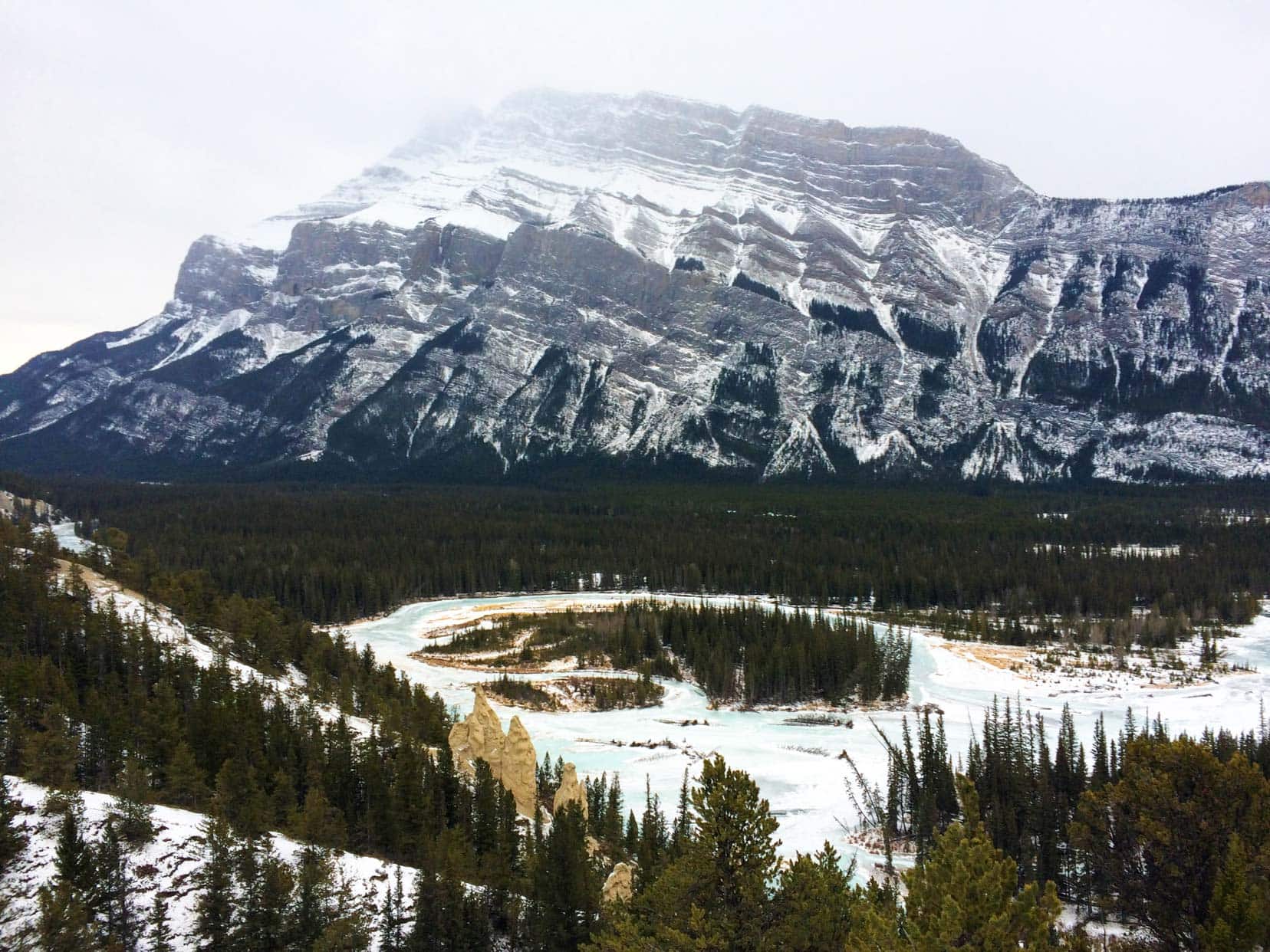 Christmas-In-Banff-Hoodoos - side of mountain with rock formations sticking up like pillars 