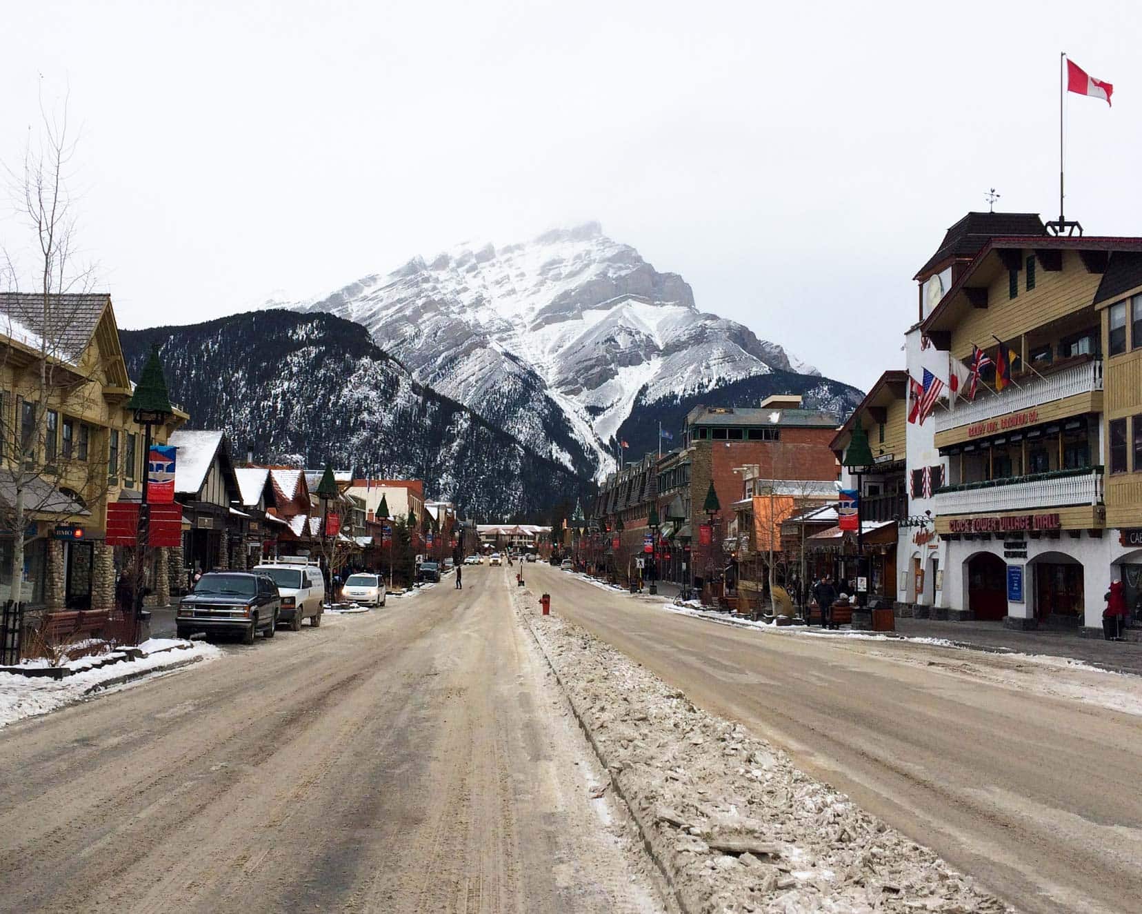 Banff town at Christmas time with snow covered bountain in the background, slushy snow on the road 