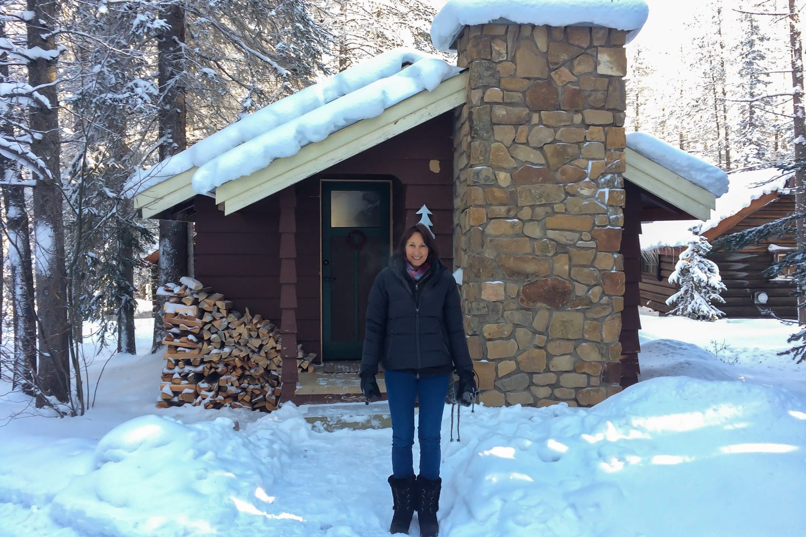 Shelley stood by log cabin in Banff at Christmas