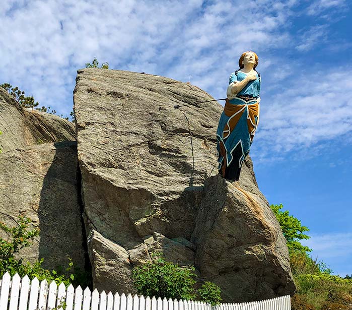 The boat figurehead of a woman attached to the rock at the entrance to Skudeneshavn Park