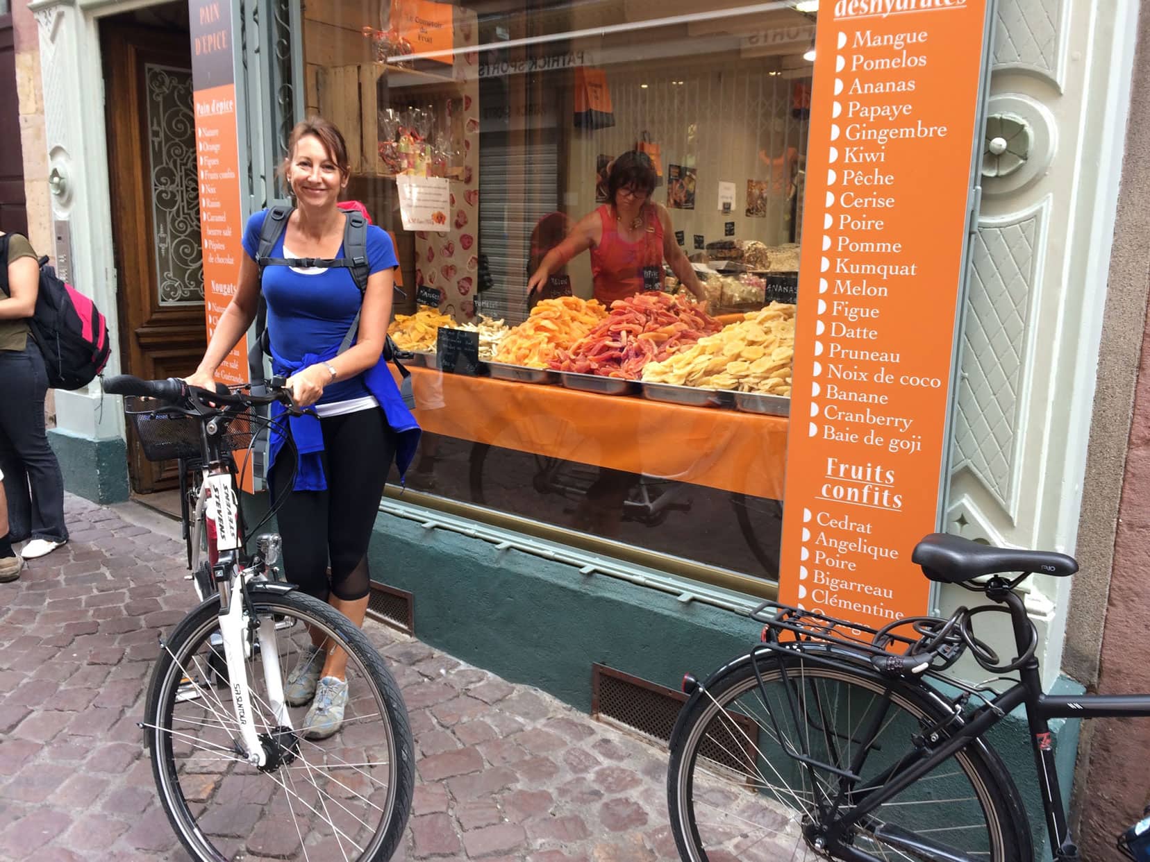 Shelley stood by bike by a dried fruit store in europe