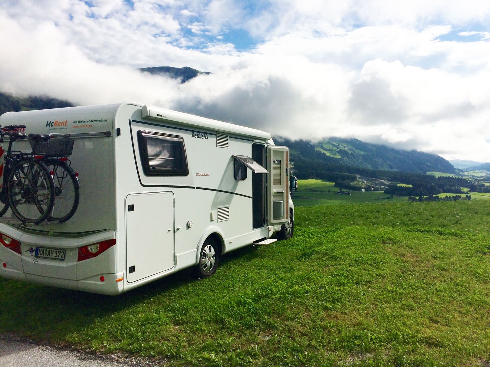 Motorhome parked witha view over the Austrian landscape of green hills and mountains