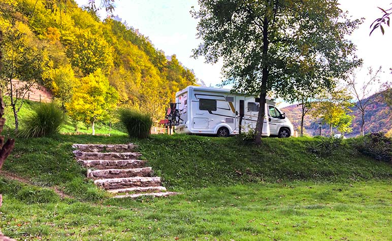 Campervan parked at a campsite in Europe surrounded by trees