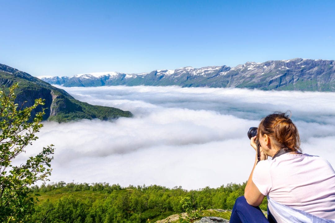 mountain views of a foggy valley with snow capped mountains alongside