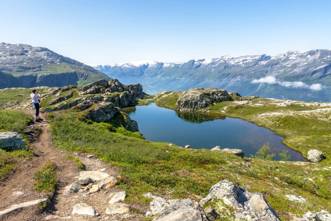 small lake on a mountain top with surrounding mountains 