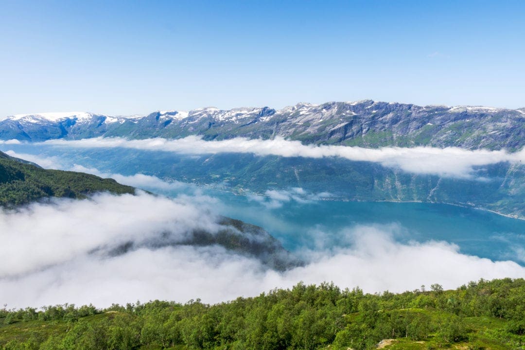 mountain views to fjord below through a cloud layer