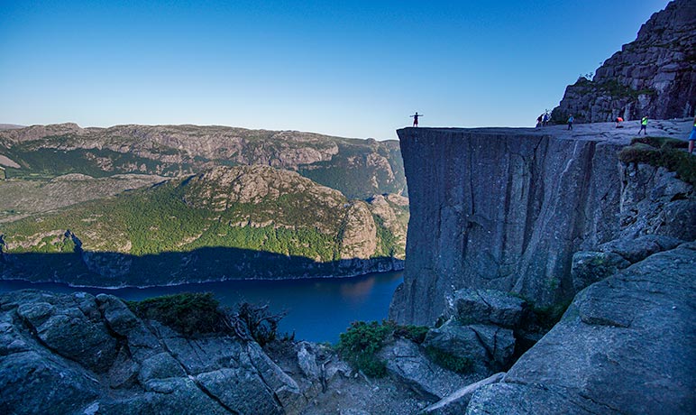 Preikestolen Hike - a person standing on Pulpit Rock - Hiking Norway 