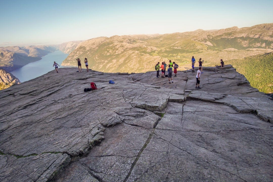 Plateau of rock high above a fjord and surrounding mountains