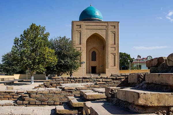 Simple mausoleum of earthen bricks and blue domed roof