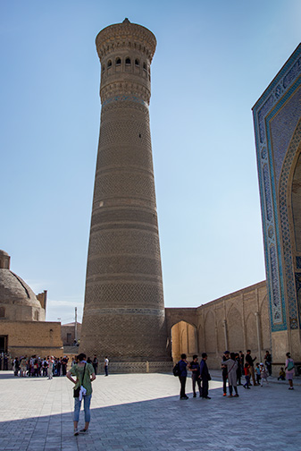 An earthen bricked minaret by day