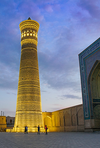 A beautifully lit golden minaret at night
