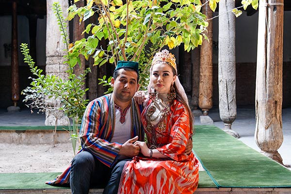 Local Uzbek wearing traditional clothing and sitting inside a mosque