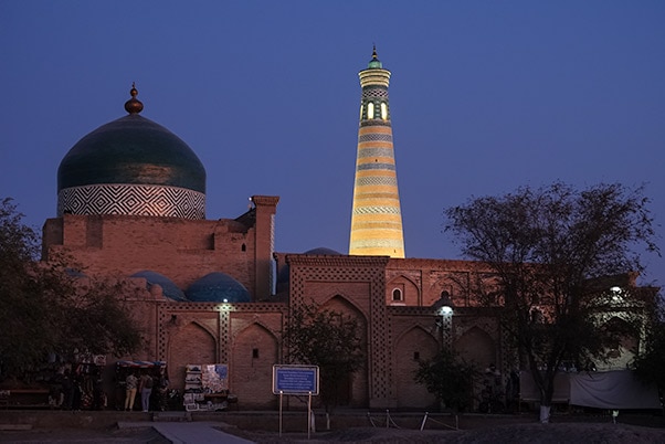 Mausoleum of Makhmud Pakhlavan (Pakhlavan Mahmud Complex) at sunset with a minaret in the background