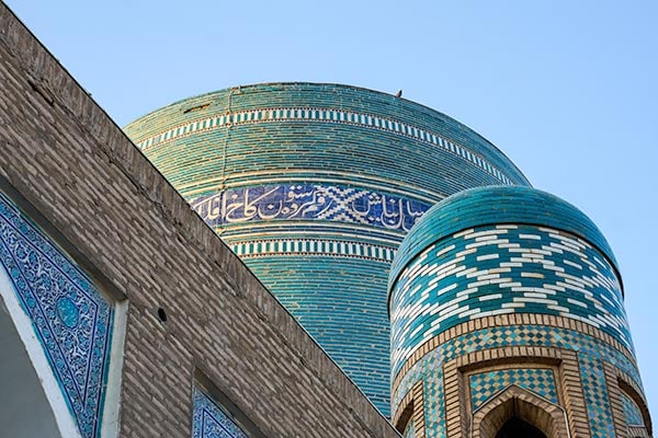 Beautiful tiled mosaics of a madrasah and minaret in Uzbekistan