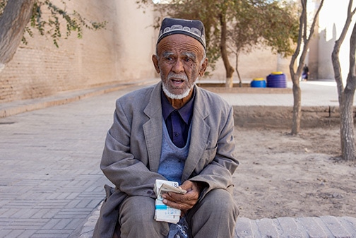 Old Uzbek local counting his local money in Khiva
