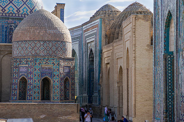 Ornate tall mausoleums butting up against each other in a narrow space