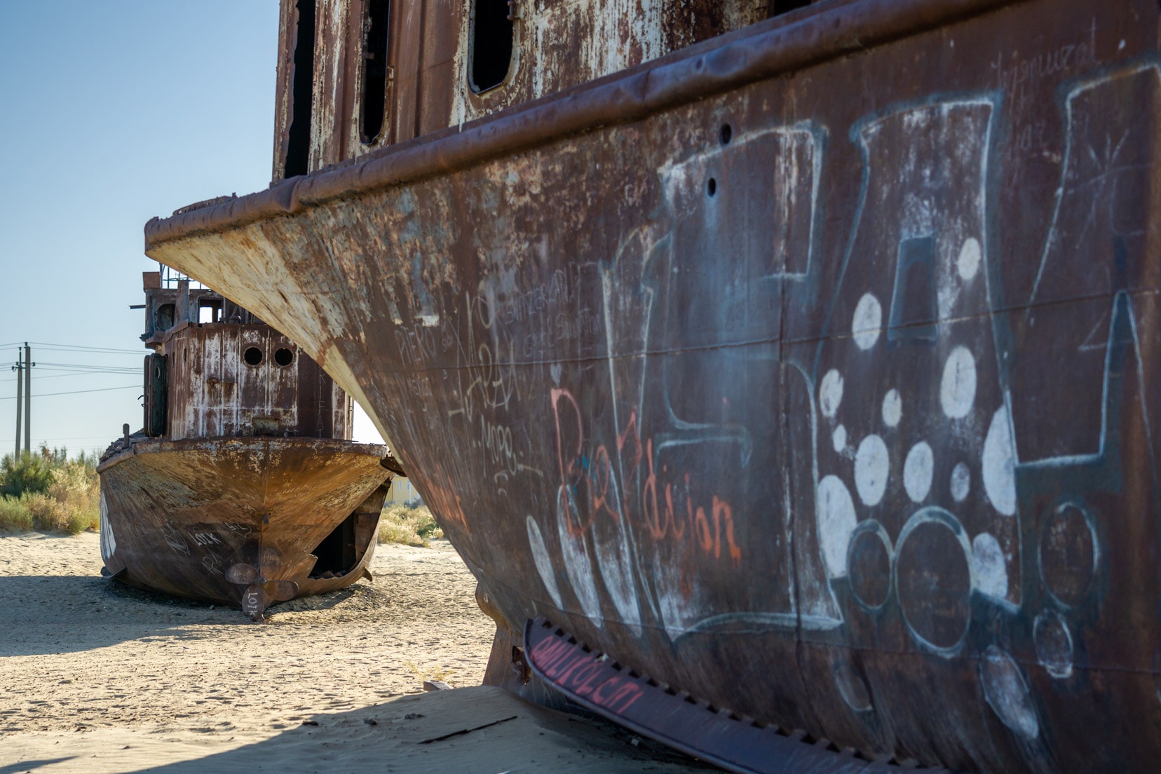 rusty-hull-of-two-ships-on-the-desert-sand