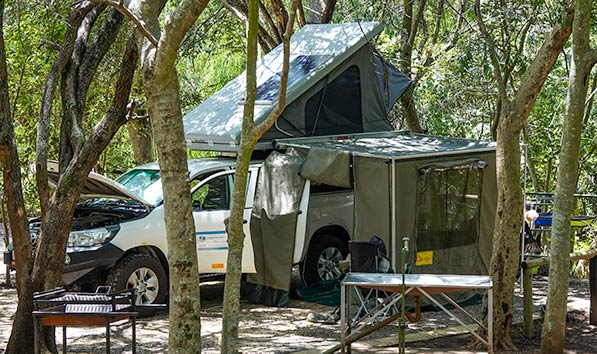 4x4 with rooftop tent up, awning extended and side panels in place