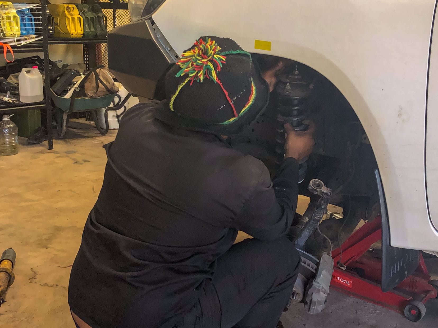 new-front-shock-absorbers being installed by a guy on a 4x4