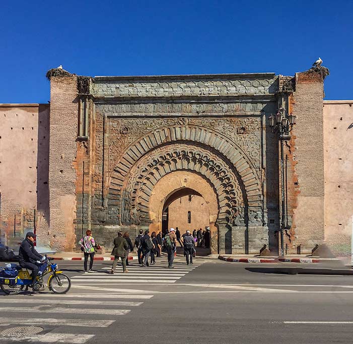 The large wooden Bar Agnaou gate with surrounding earthen walls, Marrakech