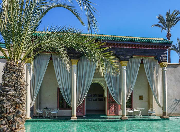 Marrakech, Marrakech showing a green tiled building with white curtains sweeping across the entrance with a vivid blue sky