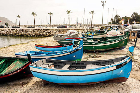 Sesimbra's bright coloured fishing boats beached at the harbour