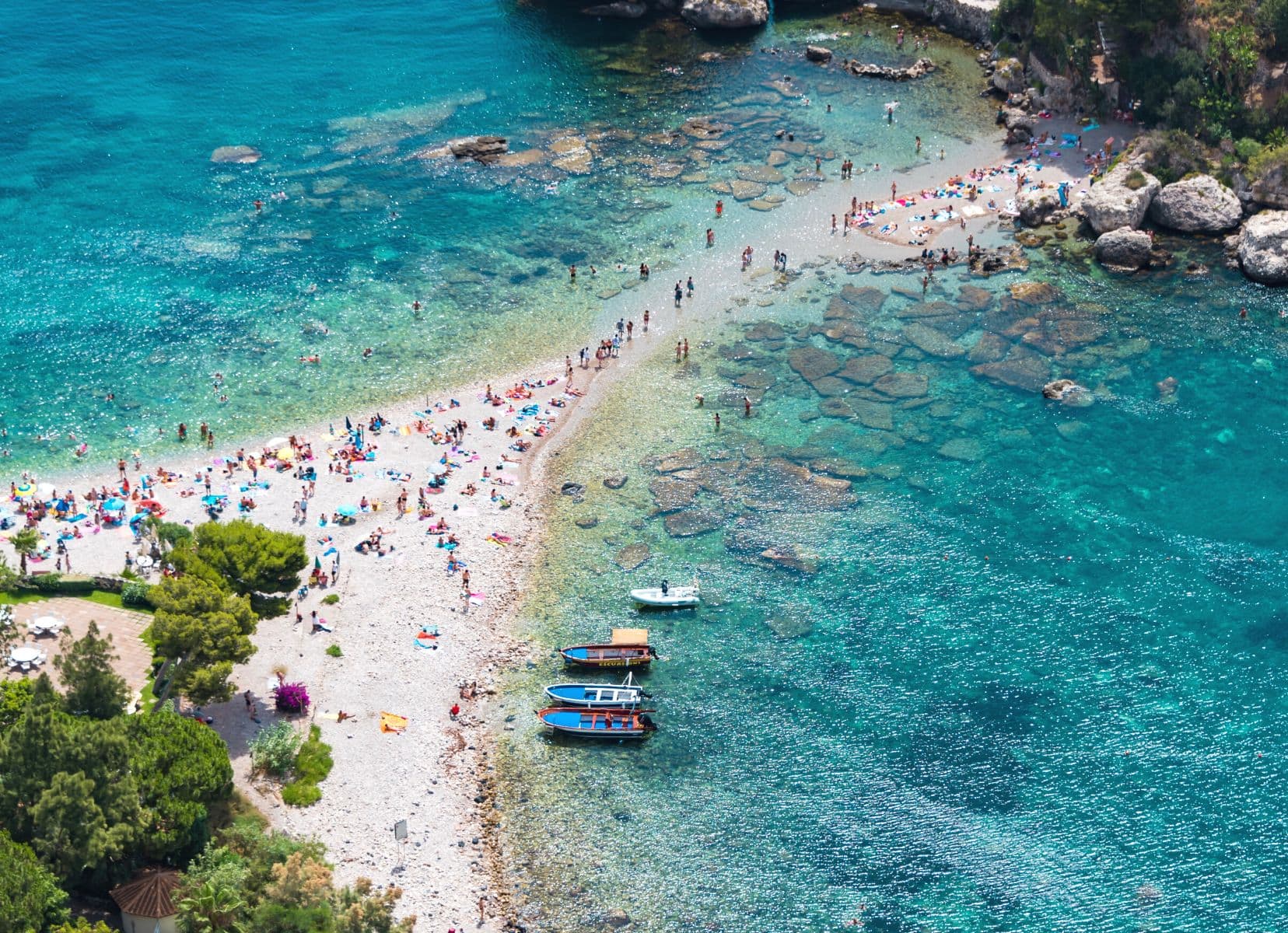 Isola Bella strip of beach covered in tourists laying on the beach in summer