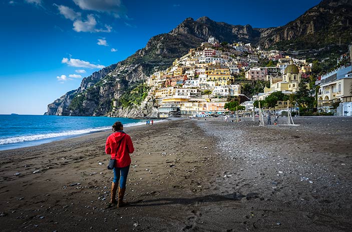 Walking along the empty beach looking towards the town of Positano on the hill