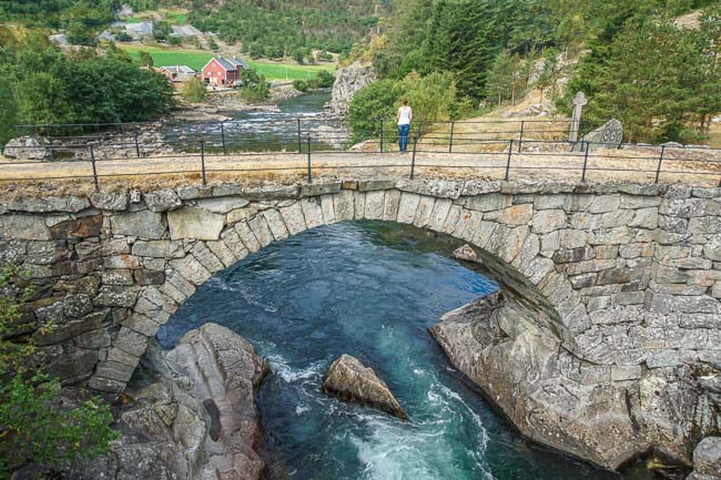 Old stony bridge over a blue water river