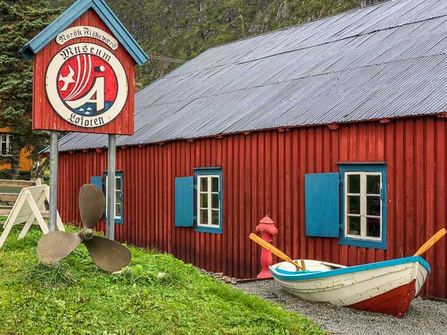 Red wooden fishing museum with oar boat outside