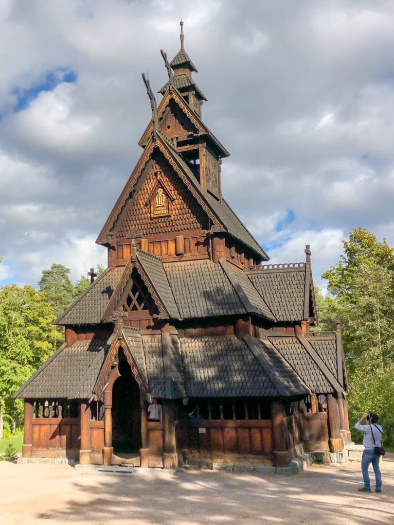 man phootgraphing a stave church from outside