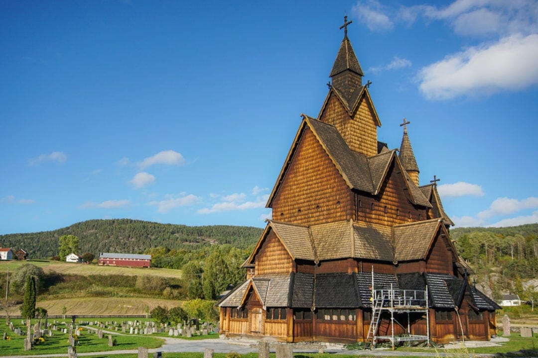 Heddal stave church undergoing painting with pine tar