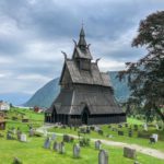 Stave church with a fjord and mountains as a backdrop