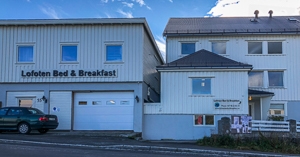 Exterior of a plain white hotel with its name on it